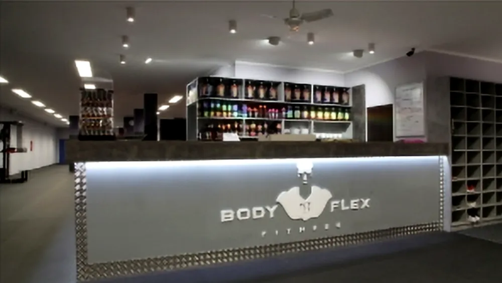 Podsvícený recepční pult s regály ve fitness centru